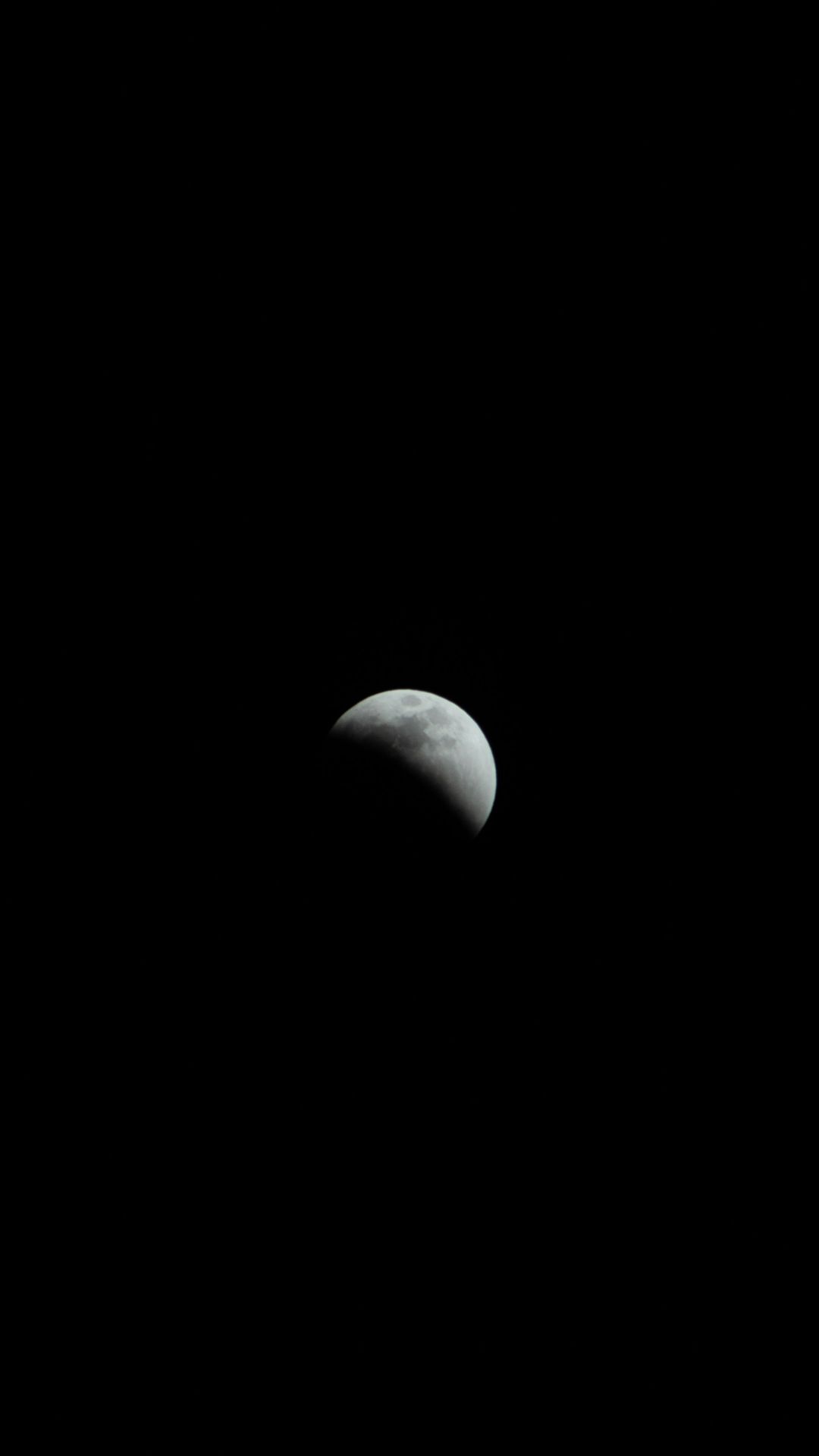 the moon is seen in the dark sky